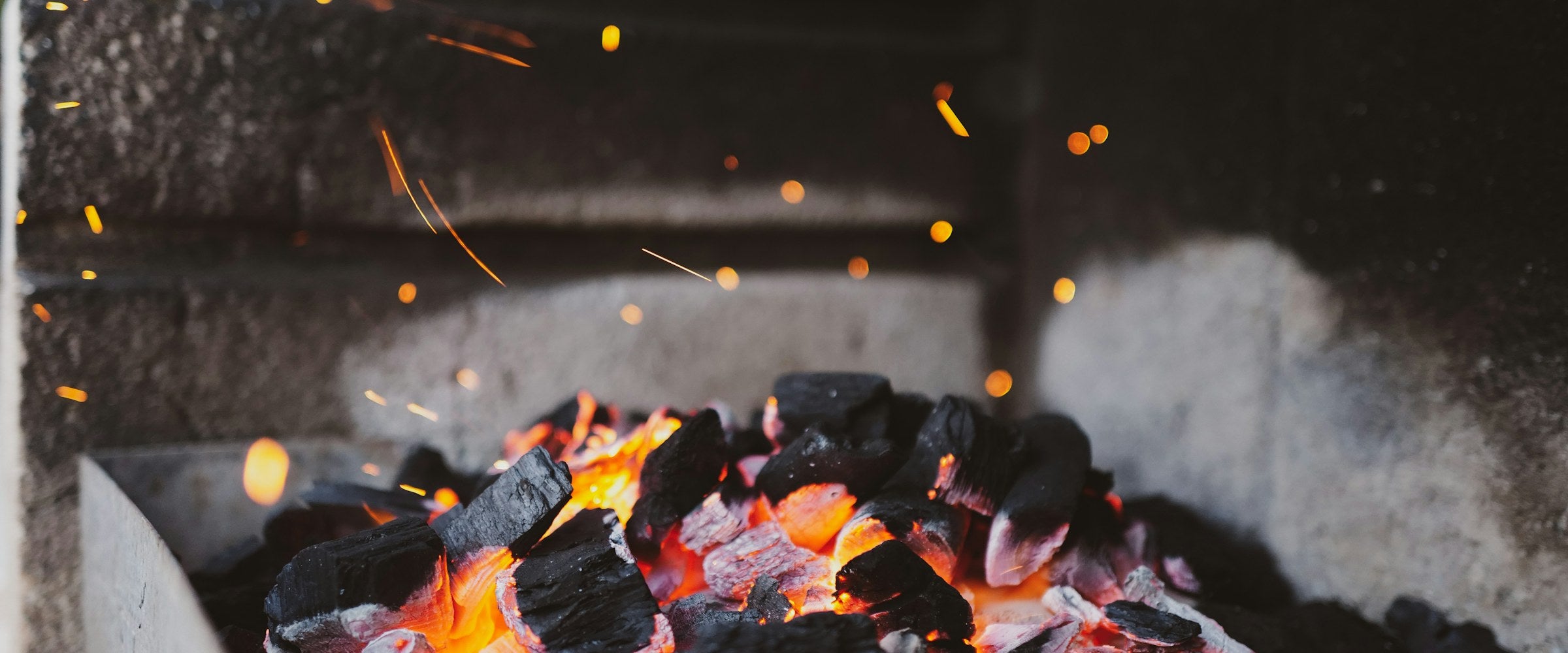 Glowing embers in a fire feature at dusk