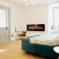 Slim wall-mounted linear electric fireplace on a bedroom wall