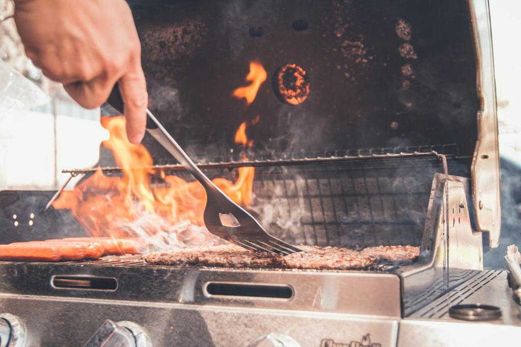 Grilling on a stainless steel gas grill with spatula