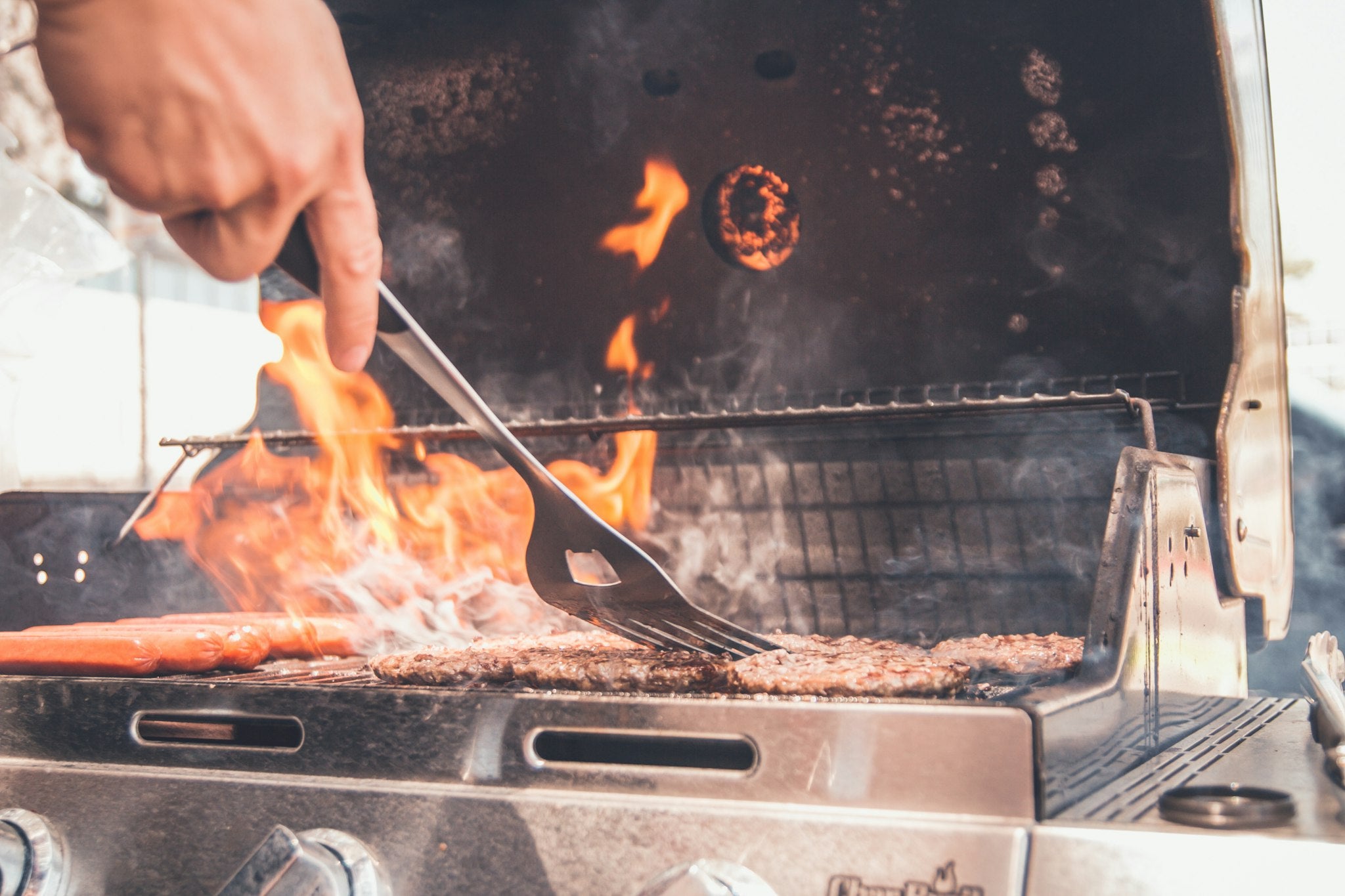 Grilling on a stainless steel gas grill with spatula