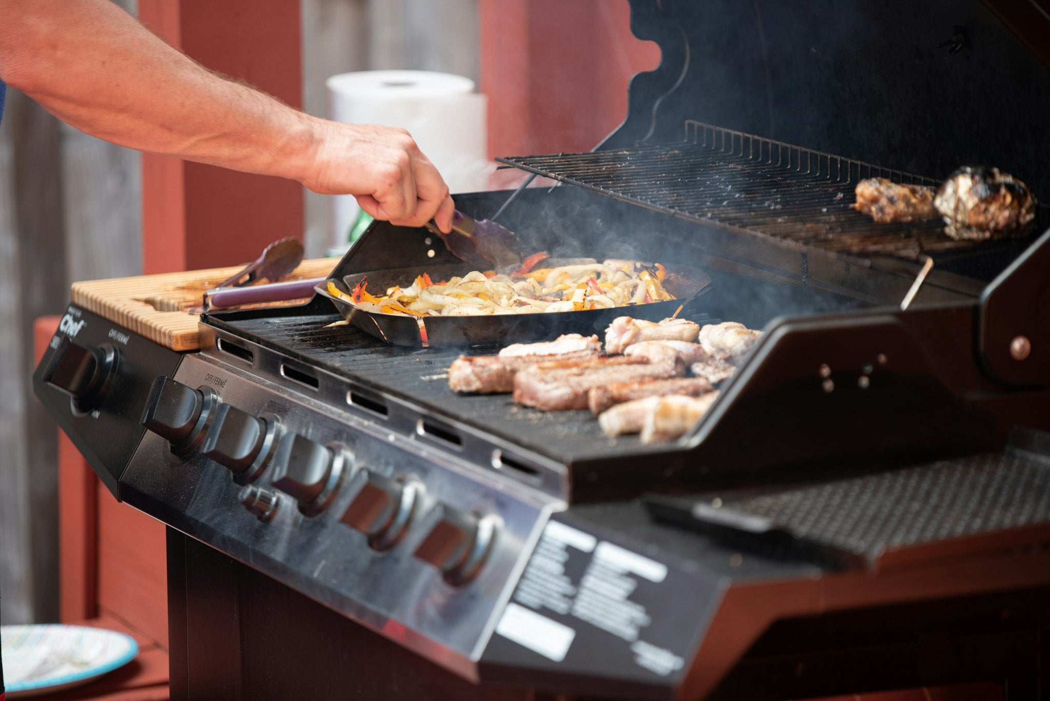 Grilling steaks on an open stainless gas grill