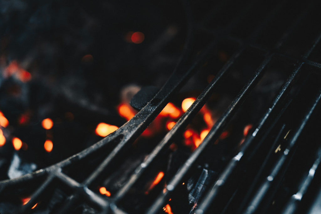 Close-up of grill grates over glowing embers
