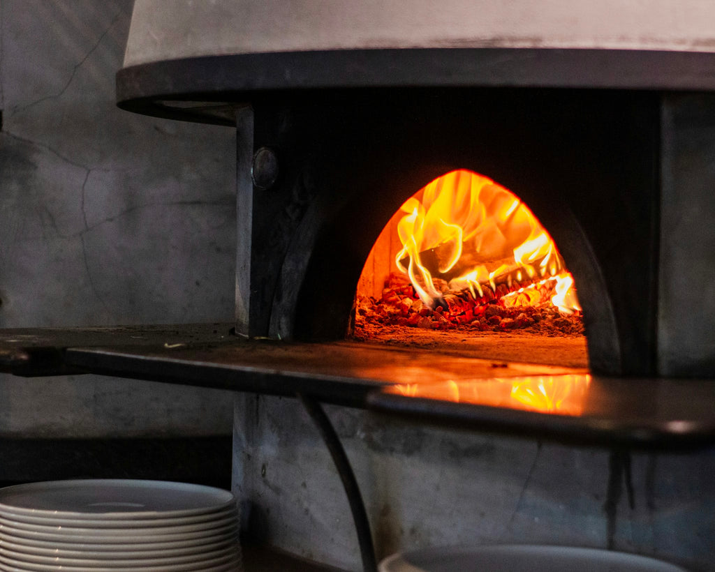 Wood-fired pizza oven with live fire glowing inside