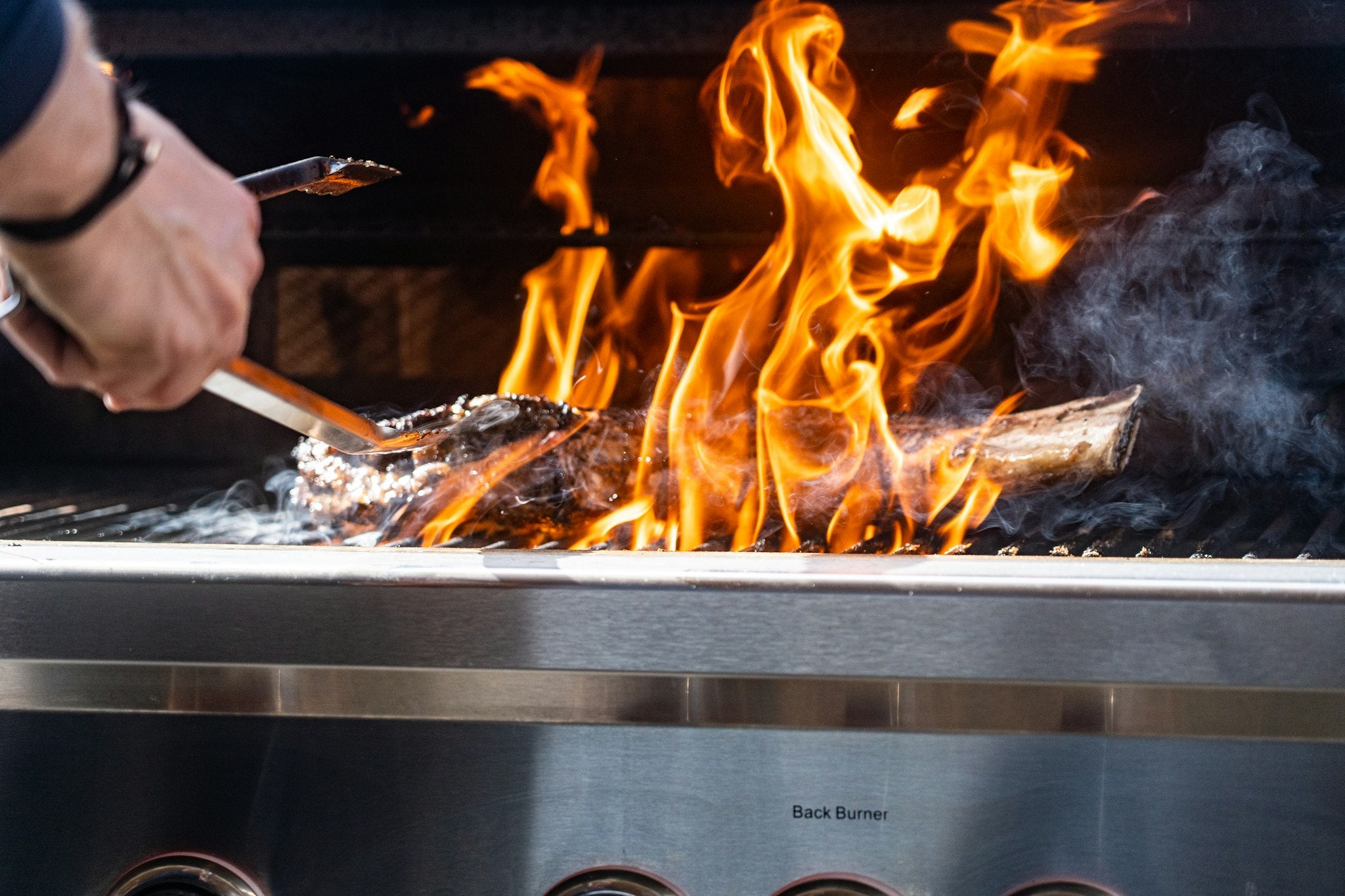 Searing over high flames on a stainless built-in gas grill