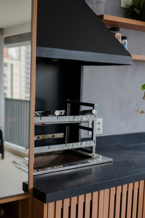 Contemporary built-in barbecue grill with hood in outdoor kitchen cabinetry